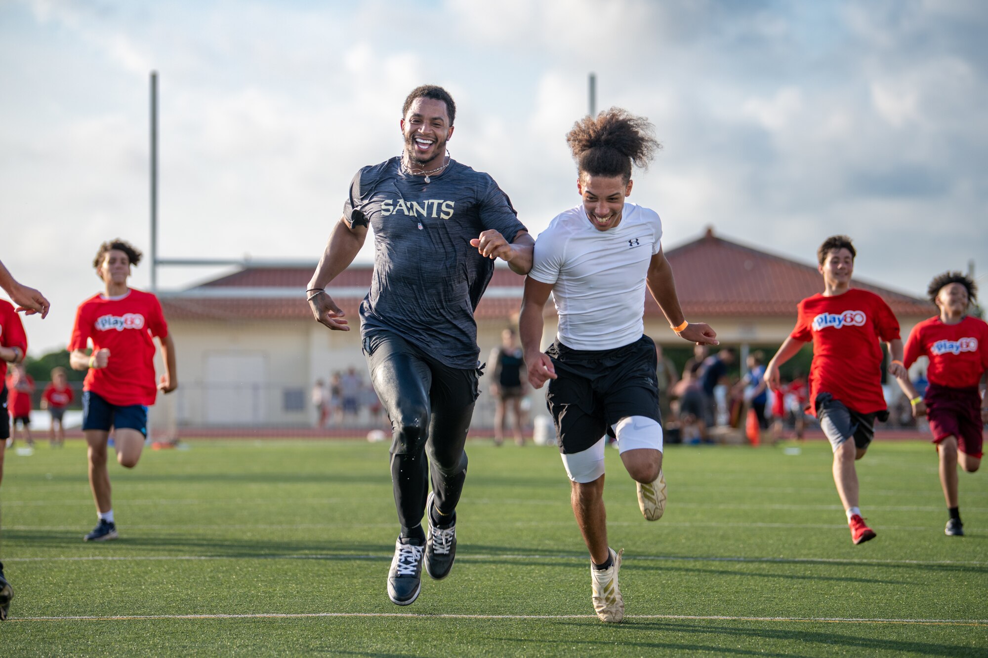 People run across a football field.