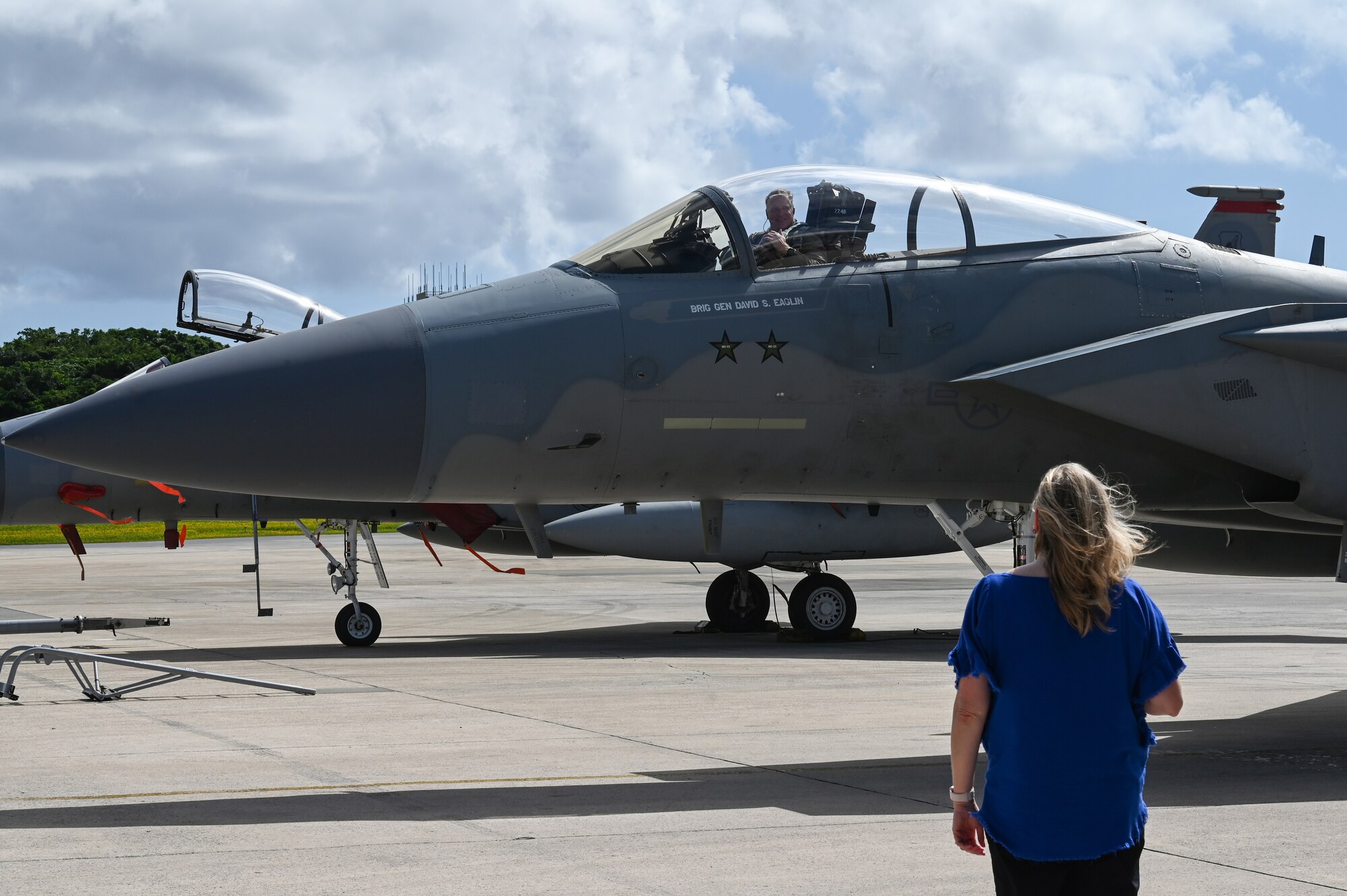 The wing commander looks at family from the cockpit.