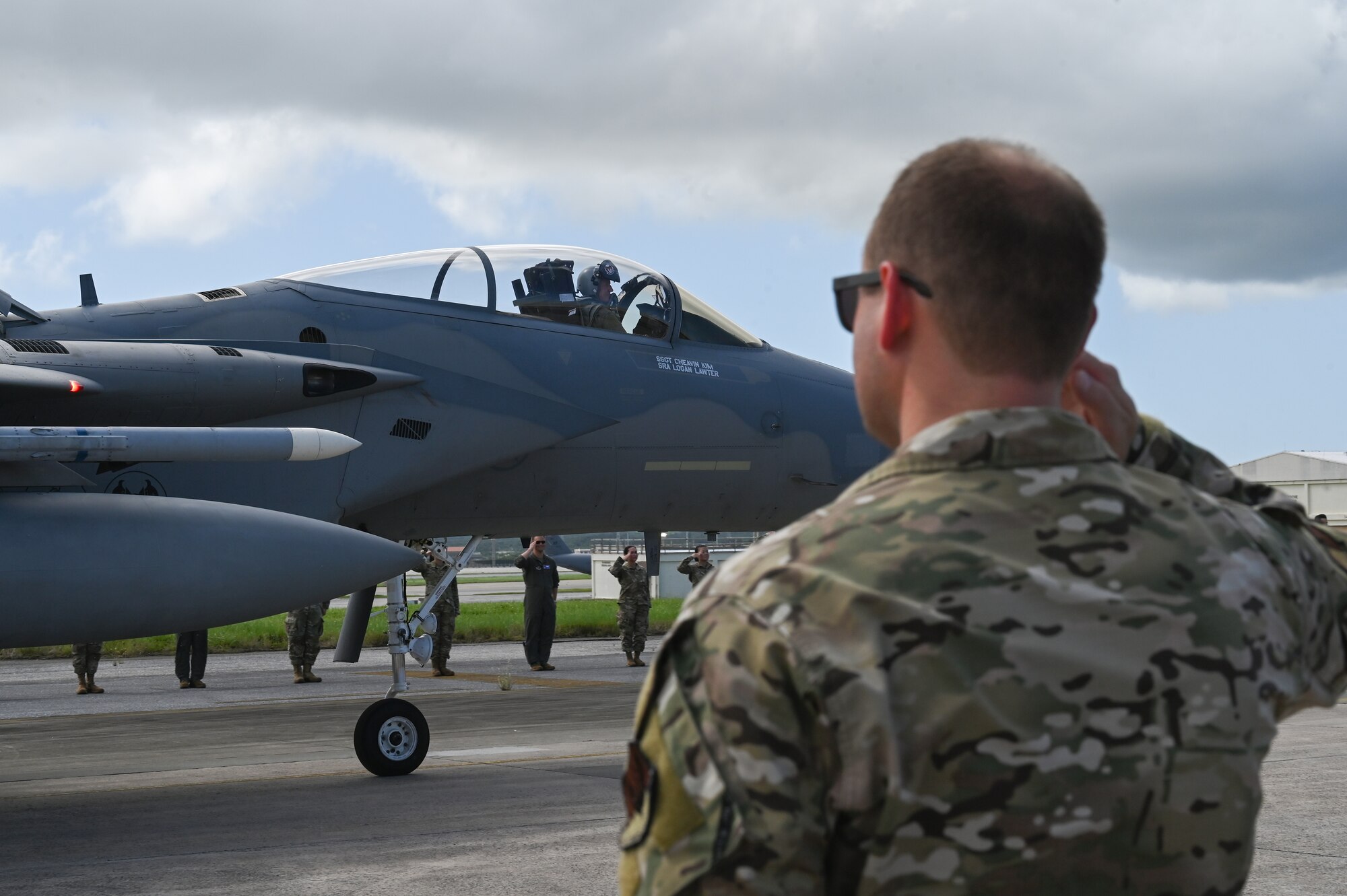 Airmen salute the commander as he taxis by.