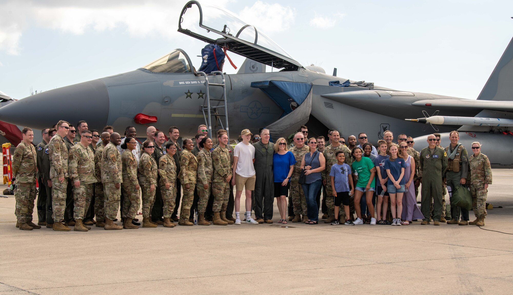 Airmen, family and friends pose for a group photo.