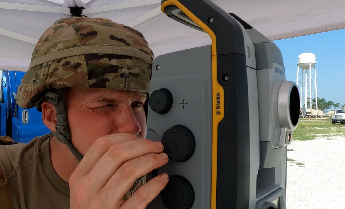 Airmen dials in a focus on his teammate during surveying operations
