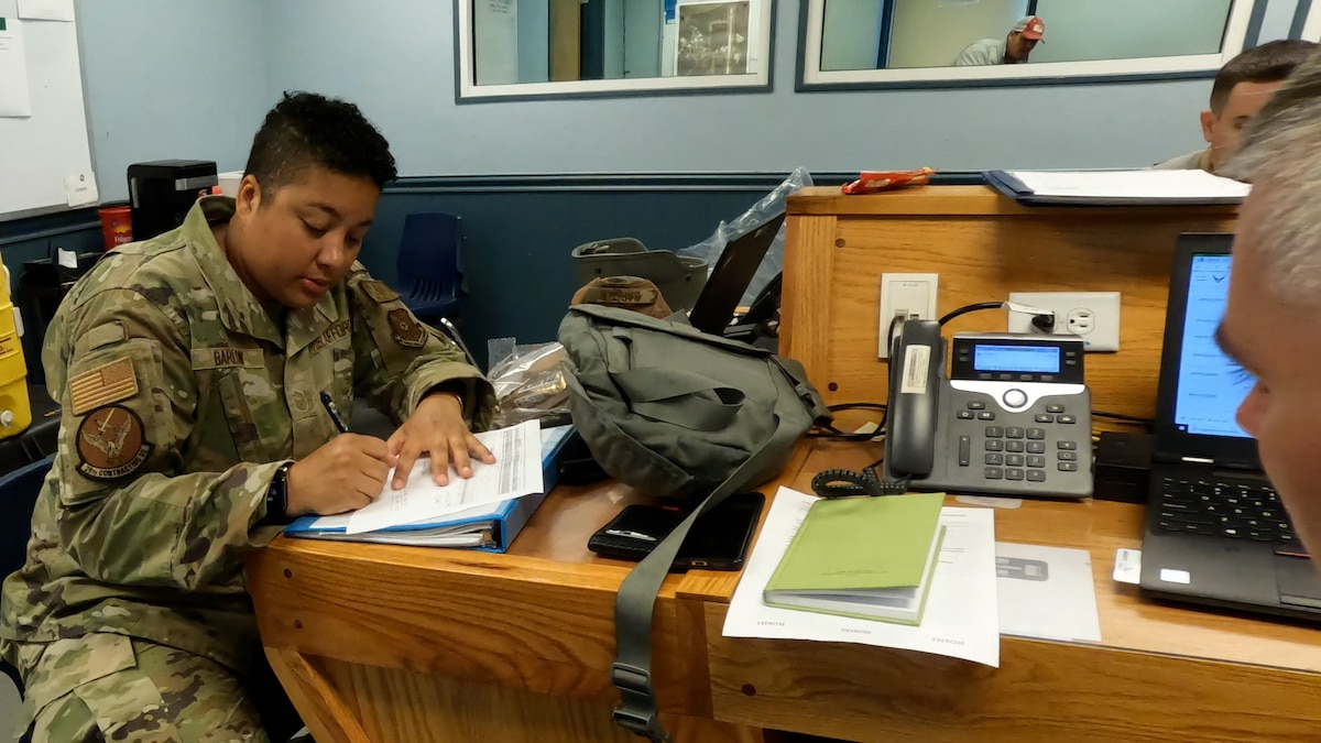 Barlow sitting at a table in operations center writing