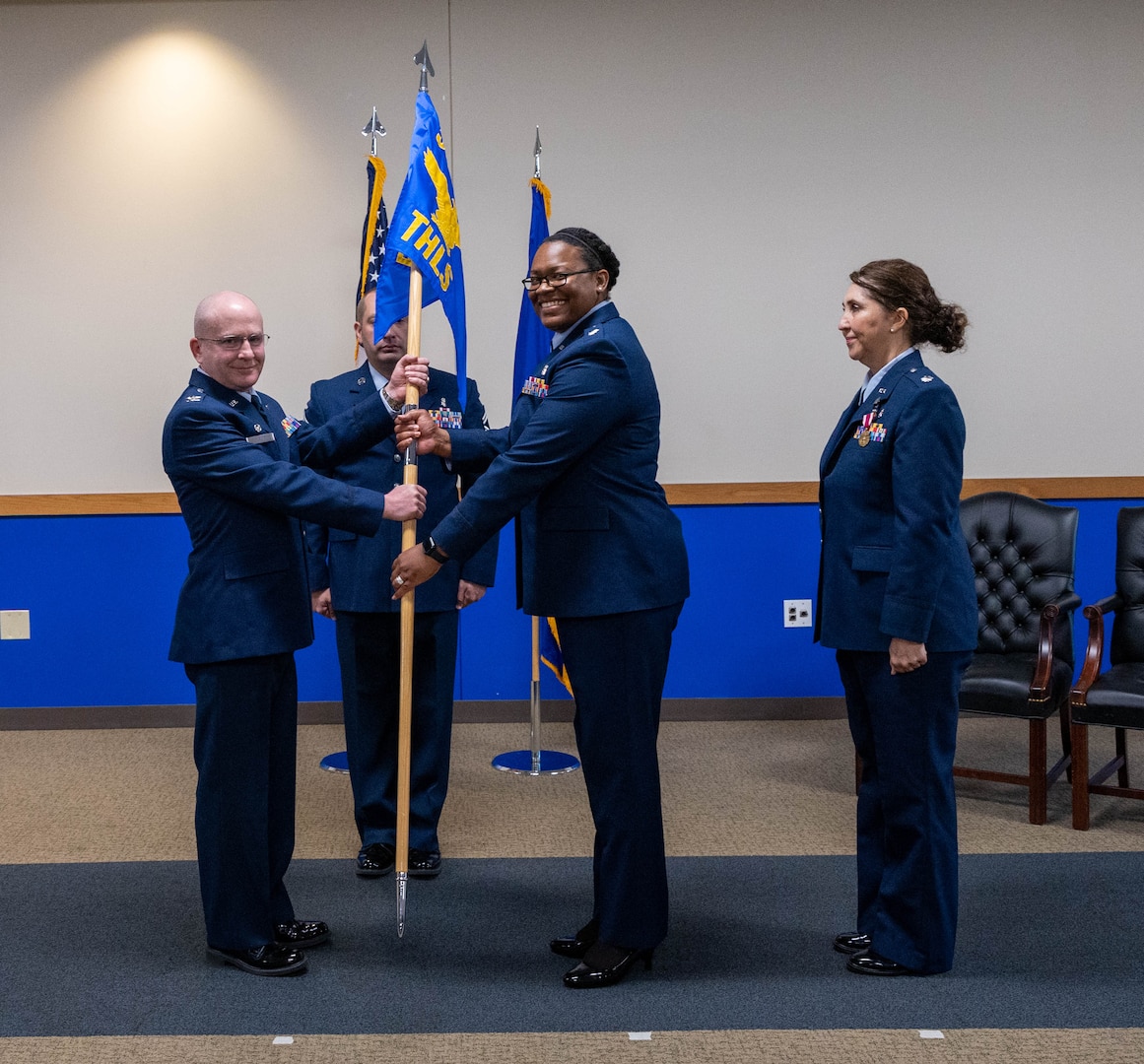 Lt. Col. Lena Williams Cox receives the 559 Trainee Health Squadron guidon flag which signifies their unit designation and branch/corps affiliation or the title of the individual who carries it.