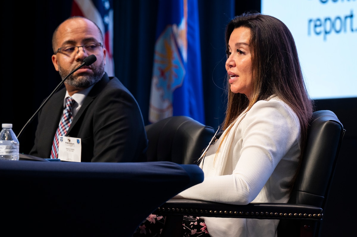 Seated speakers at panel presentation.