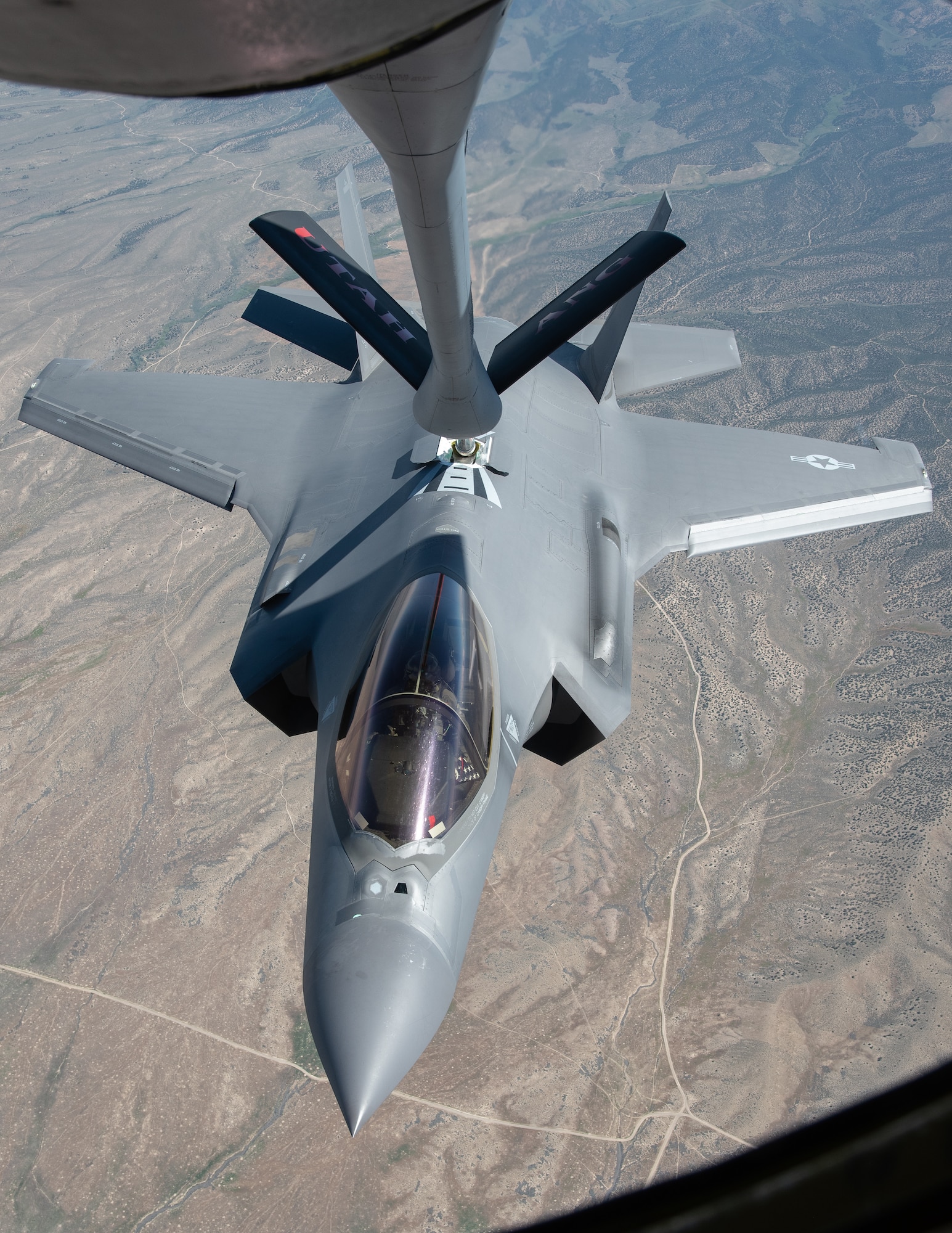 An F-35 fighter aircraft flies with a KC-135 refueler