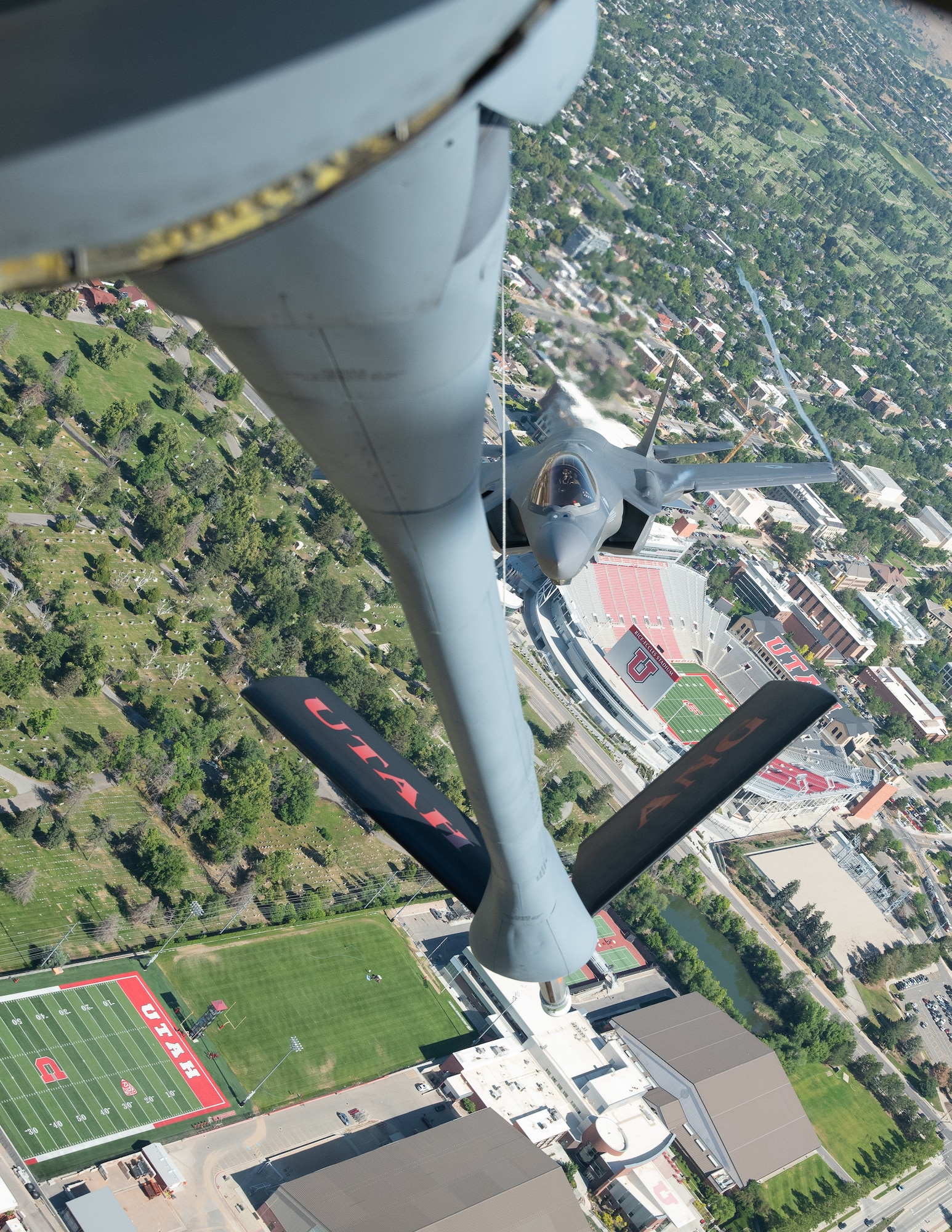 An F-35 fighter aircraft flies with a KC-135 refueler