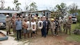 Guam residents and members of Task Force RISEUP, which is short for Roofing Installation Support Emergency Utilization Program, celebrate completion of the 100th temporary, emergency roof install during recovery efforts following Typhoon Mawar, June 27, 2023.