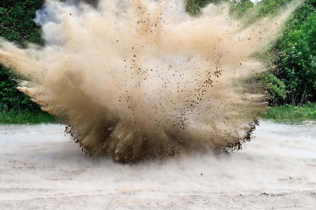 A mine explodes sending up a cloud of dust.