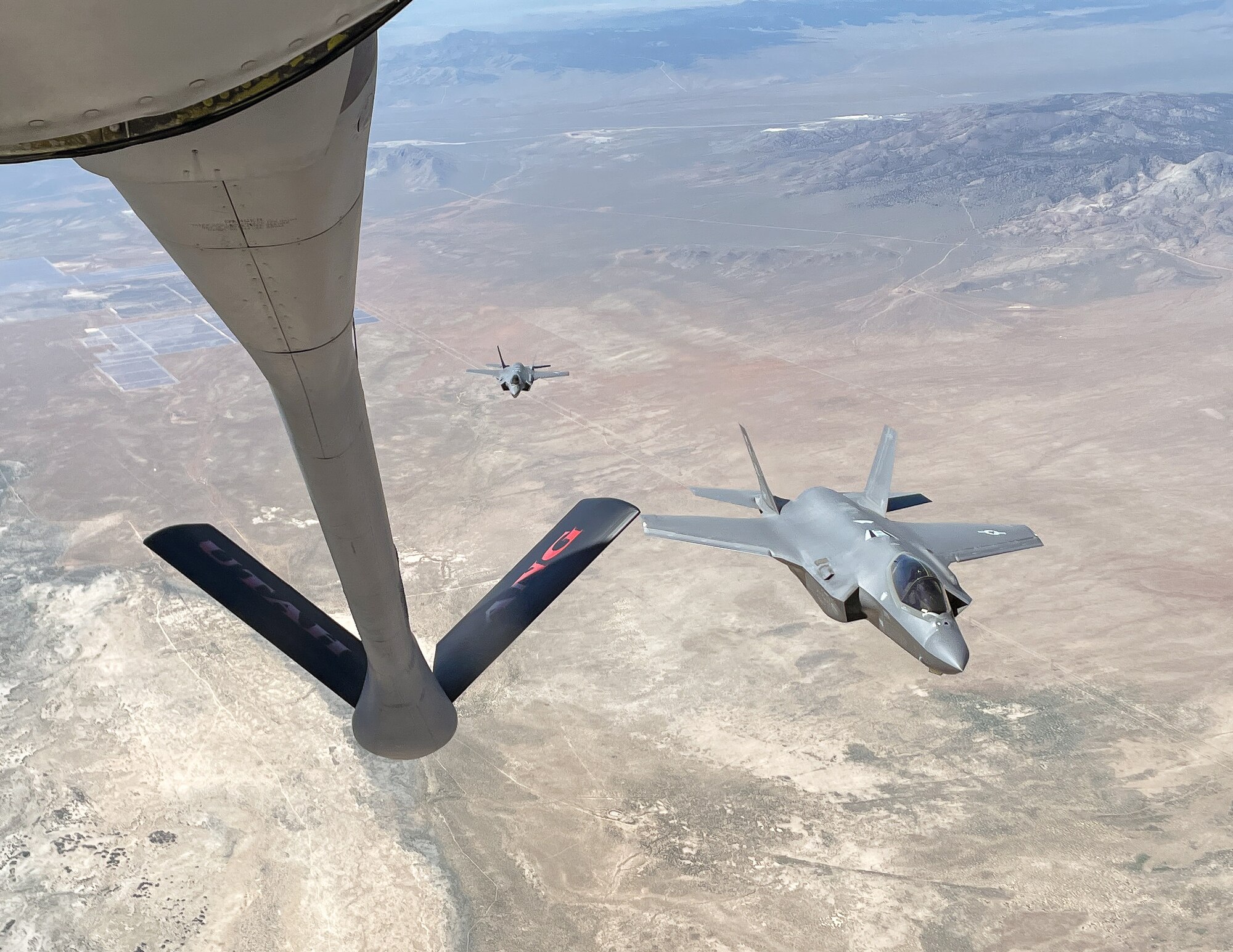 An F-35 fighter aircraft flies with a KC-135 refueler