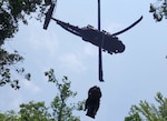 Sgt. 1st Class Giovanni DeZuani, a fight paramedic with the Tennessee Army National Guard, is hoisted into a hovering Black Hawk helicopter with an injured hiker immobilized on a stretcher during a rescue at the Cumberland Gap National Historic Park June 28, 2023.