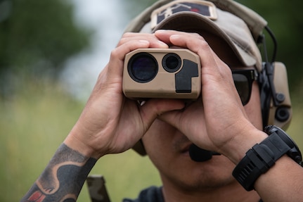 U.S. Air Force Senior Airman Richie Thammavongsa, tactical air control party specialist with the 146th Air Support Operations Squadron, 137th Special Operations Wing, Oklahoma National Guard, determines the distance to a point using a pocket laser range finder as the team rehearses reconnaissance operations during exercise Air Defender 2023 (AD23) in Germany June 19, 2023. Exercise AD23 is a German-led exercise that integrates both U.S. and Allied air-power to defend shared values, while leveraging and strengthening vital partnerships to deter aggression around the world. (U.S. Air National Guard photo by Tech. Sgt. Brigette Waltermire)