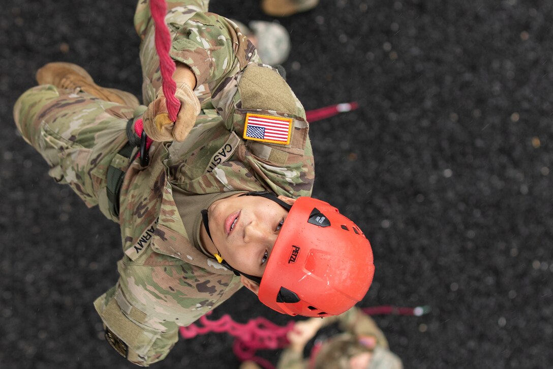 An Army cadet rappels down a tower.