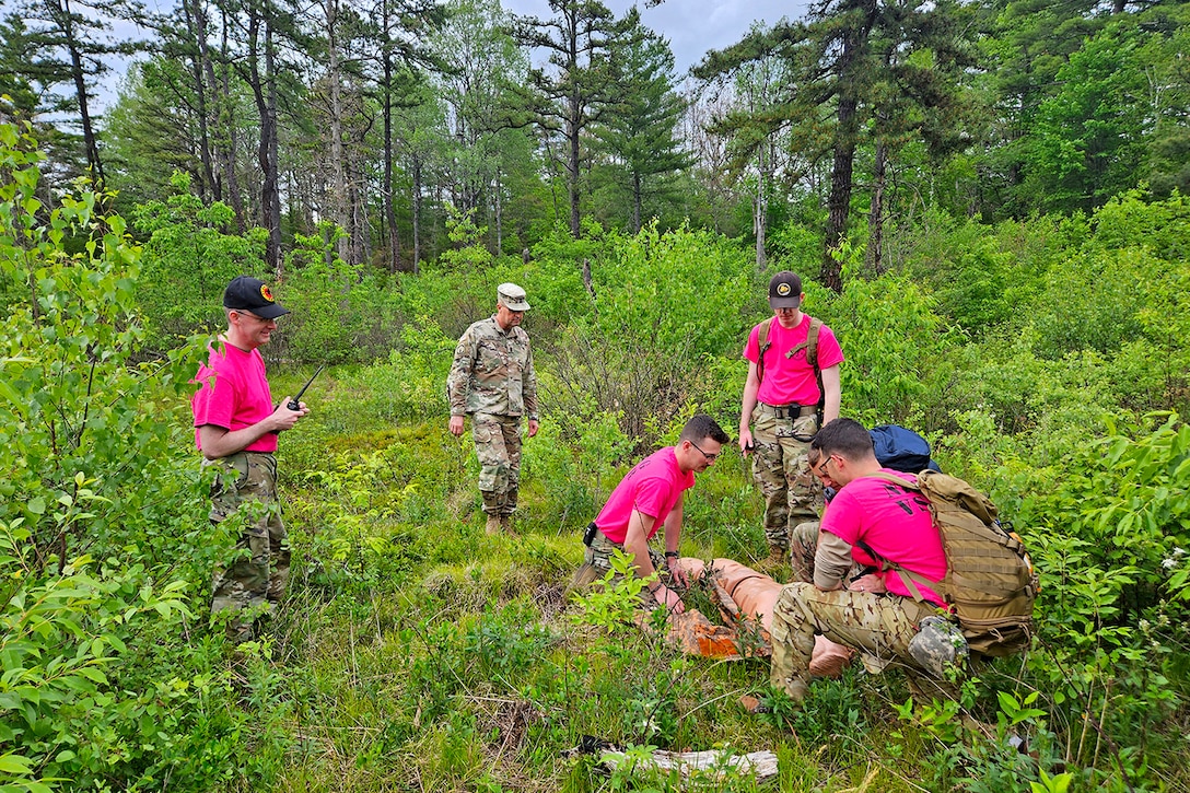 National Guardsmen train on search and rescue techniques with a simulated casualty in a wooded area.