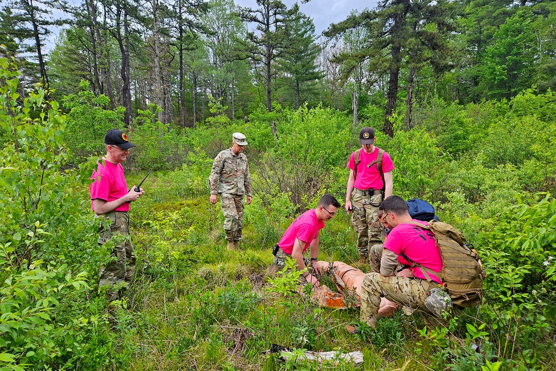 National Guardsmen train on search and rescue techniques with a simulated casualty in a wooded area.