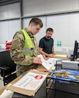 U.S. Army Reserve Spc. Jozeph Dybalski, of the 341st Medical Logistics Company supply platoon, works alongside supply technician Aaron Miller in the U.S. Army Medical Materiel Center-Europe’s cold-chain storage warehouse during Operation Patriot Press in May. (Photo Credit: Spc. Zoe Horton