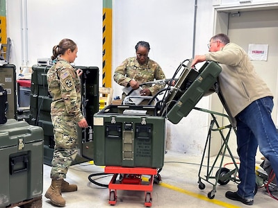 U.S. Army Reserve Sgts. Alanna Yeutter, left, and Rebecca Robinson, of the 341st Medical Logistics Company maintenance platoon, perform preventative maintenance services on a portable oxygen generator system at the U.S. Army Medical Materiel Center-Europe during Operation Patriot Press in May. Also pictured is Don Shelton, a biomedical equipment technician with USAMMC-E’s Clinical Engineering Division. (Photo Credit: Staff Sgt. Christopher Norwood)