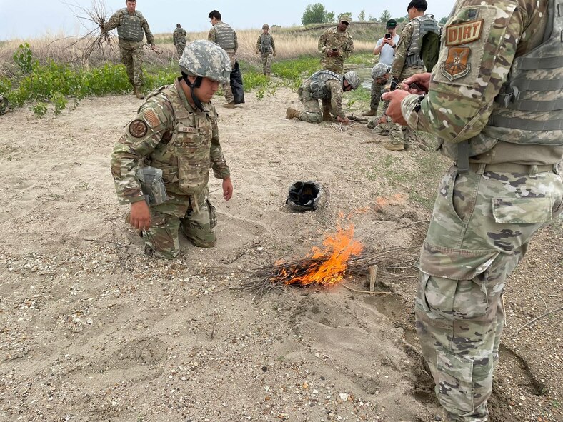 Airmen from the 5th Civil Engineering Squadron tend to a fire for a training event June 15, 2023 at Minot Air Force Base, North Dakota. The Airmen split into tiers of ranks enabling the group to work with their peers and take leadership roles. The Airmen were taught to be more multi-capable and effective when deployed to an area focused on Agile Combat Employment. (Courtesy photo.)