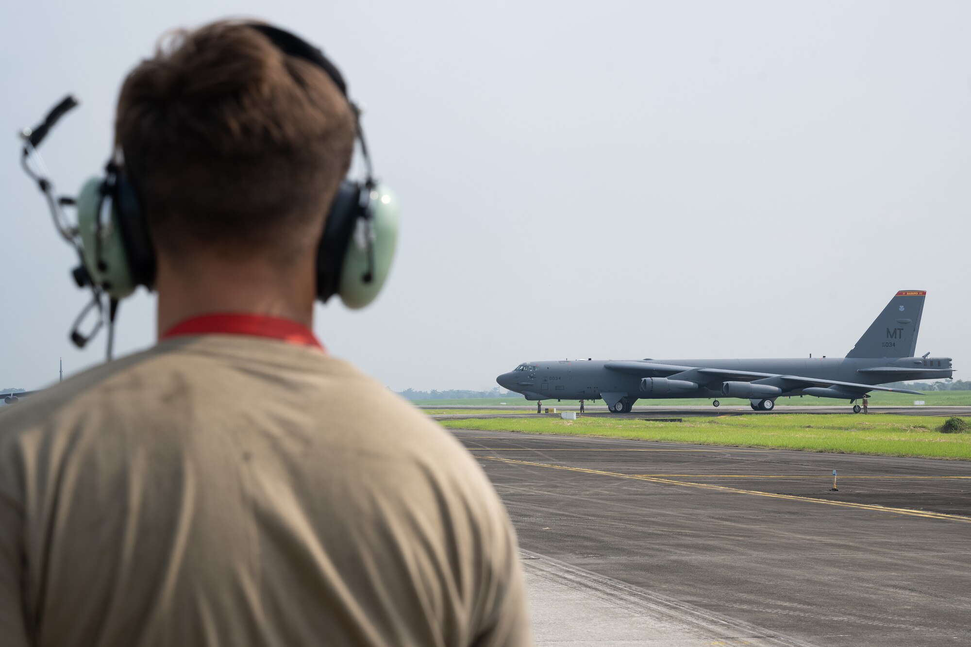 A U.S. Airman assigned to the 5th Aircraft Maintenance Squadron at Minot Air Force Base, North Dakota, prepares to marshal a B-52H Stratofortress assigned to the 23rd Bomb Squadron following a bilateral military training exercise at the Kualanamu International Airport in Medan, Indonesia, June 21, 2023. The U.S. Air Force routinely and visibly demonstrates commitment to its allies and partners through the global employment of military forces. This particular training flight marked the first time a U.S. Air Force B-52 had taken off from Indonesian soil. (U.S. Air Force photo by Tech. Sgt. Zade Vadnais)