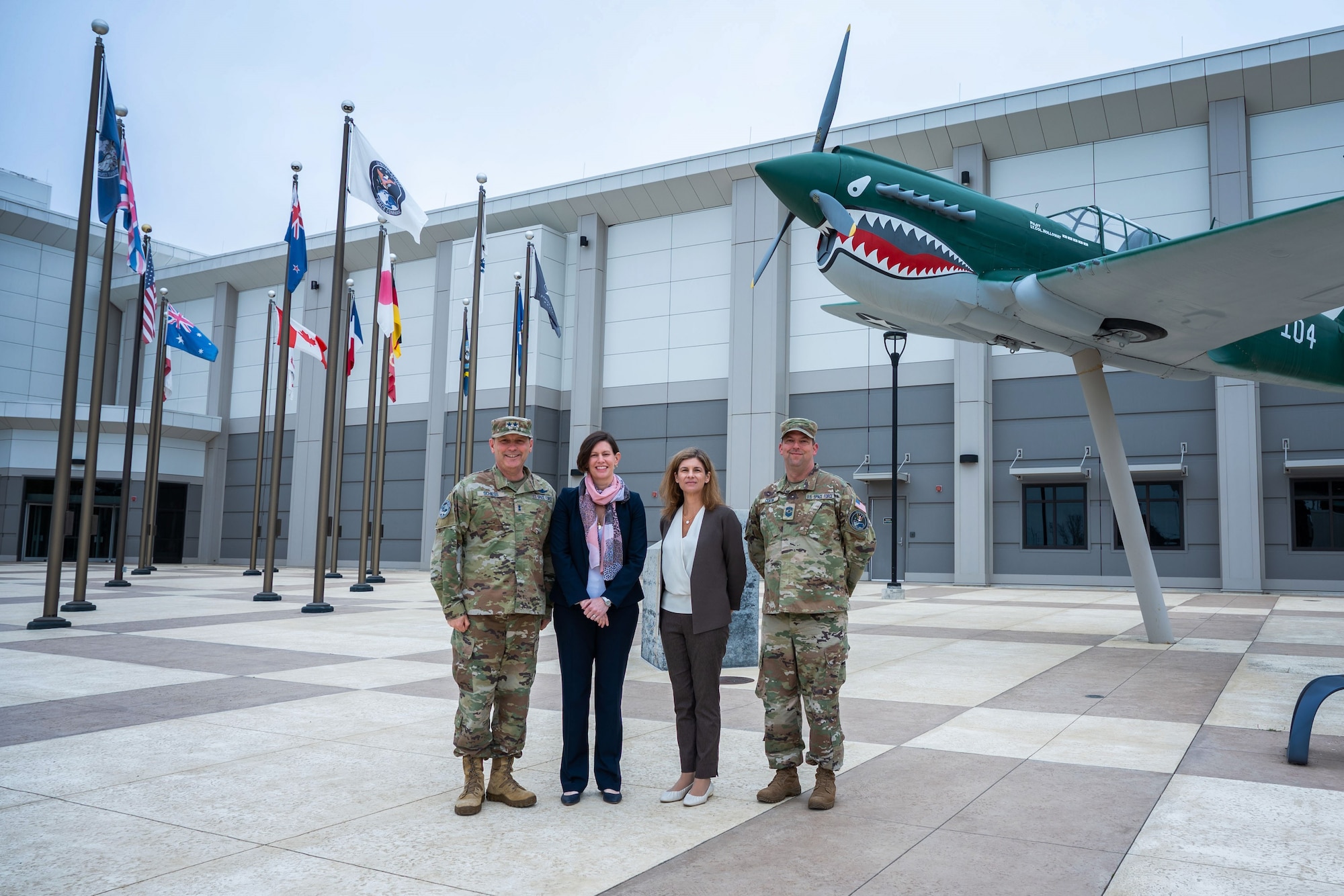 (From left to right) U.S. Space Force Maj. Gen. Douglas A. Schiess, Combined Force Space Component Command (CFSCC) commander, Ms. Stephanie Miller, Deputy Assistant Secretary of Defense for Military Personnel Policy, Ms. Katharine Kelley, Deputy of Space Operations for Human Capital, and Chief Master Sgt. Grange S. Coffin, CFSCC Senior Enlisted Leader, stand together for a photo in front of CFSCC Headquarters on Vandenberg Space Force Base, Calif., June 27, 2023. (U.S. Space Force photo by Tech. Sgt. Luke Kitterman)