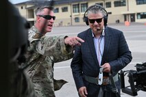 Two men prepare to ride in a helicopter.