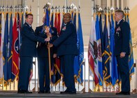 U.S. Air Force Col. Rofelio Grinston, 5th Maintenance Group (MXG) commander, accepts the guidon from Col. Daniel Hoadly, 5th Bomb Wing commander, during the 5th MXG change of command ceremony at Minot Air Force Base, North Dakota, June 29, 2023. Hoadly passed the guidon to Grinston as a symbol of trust for taking command of the MXG. (U.S. Air Force photo by Senior Airman Evan Lichtenhan)