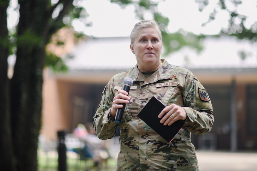 Woman in military uniform holding a microphone.