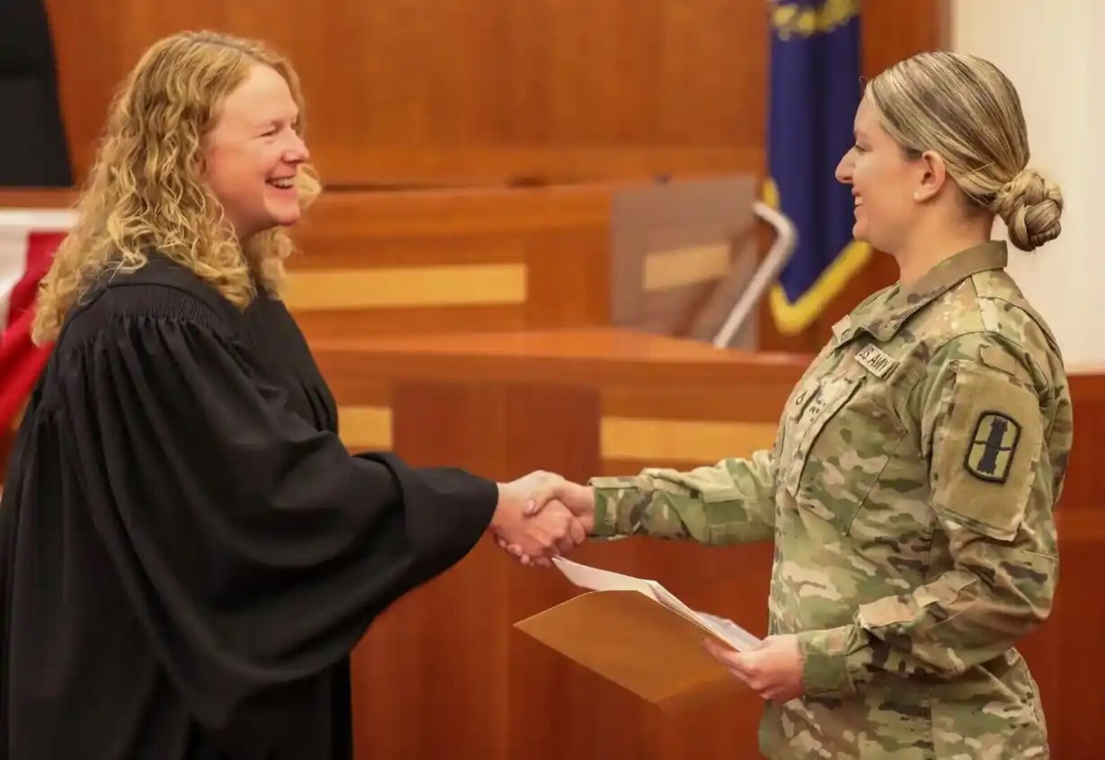 Pfc. Stefane Godoes, HHB, 197th Field Artillery Regiment, New Hampshire Army National Guard, shakes hands with District Judge Samantha Elliott moments after becoming a United States citizen June 16, 2023, at the U.S. District Court in Concord.