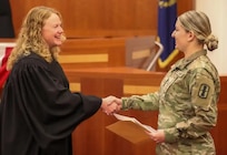 Pfc. Stefane Godoes, HHB, 197th Field Artillery Regiment, New Hampshire Army National Guard, shakes hands with District Judge Samantha Elliott moments after becoming a United States citizen June 16, 2023, at the U.S. District Court in Concord.