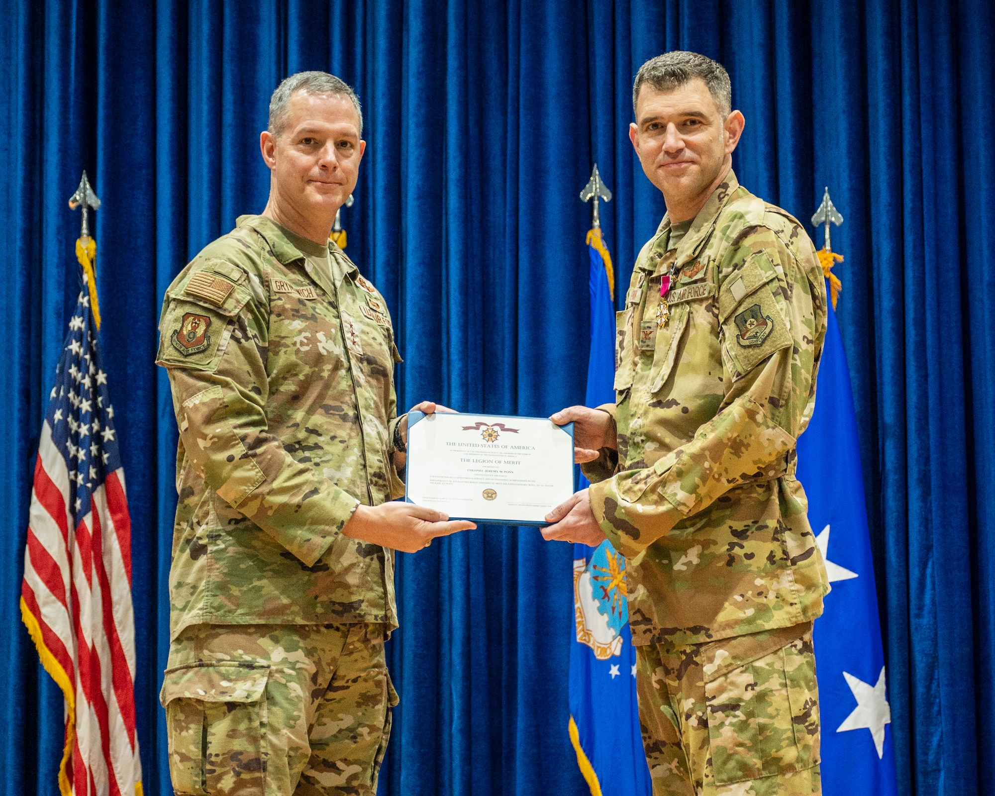 U.S. Air Force Lt. Gen. Alexus Grynkewich, Ninth Air Force (Air Forces Central) commander, presents the Legion of Merit to Col. Jeremy Ponn, outgoing 387th AEG commander, during a change of command ceremony at Ali Al Salem Air Base, Kuwait, June 30, 2023.