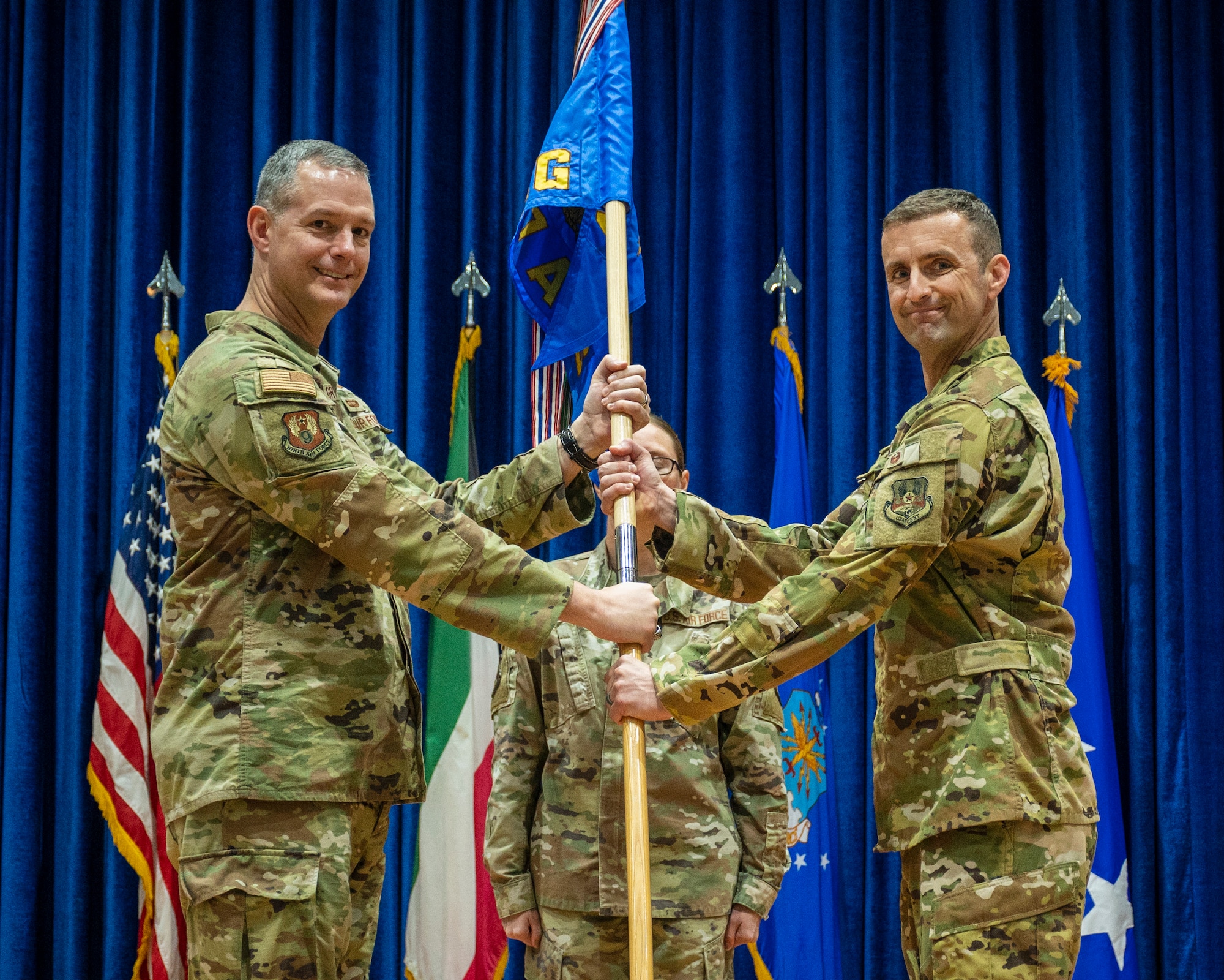 U.S. Air Force Lt. Gen. Alexus Grynkewich, Ninth Air Force (Air Forces Central) commander, passes the guidon to Col. Rhett Brown, incoming 387th Air Expeditionary Group commander, during a change of command ceremony at Ali Al Salem Air Base, Kuwait, June 30, 2023.