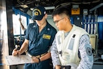 PHILIPPINE SEA (June 15, 2023) Lt. Karl Marvil, from Miami, discusses underway replenishment maneuvers with a Philippine Navy sailor aboard Ticonderoga-class guided-missile cruiser USS Robert Smalls in the Philippine Sea, June 15. The Philippines Navy sent Liaison Officers to U.S. warships to exchange maritime logistics operations knowledge in order to strengthen the U.S.–Philippines naval alliance. Robert Smalls is forward-deployed to the U.S. 7th fleet area of operations in support of a free and open Indo-Pacific. Commander, Task Force 73 (CTF-73) in coordination with Military Sealift Command Far East (MSC FE) refuels and resupplies deployed naval forces, along with regional allies and partners in the Indo-Pacific (U.S. Navy photo by Mass Communication Specialist 2nd Class RuKiyah Mack).