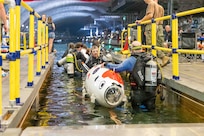 Teams enter the water at Naval Surface Warfare Center, Carderock Division's David Taylor Model Basin as they prepare for the 17th International Submarine Race in West Bethesda, Md., on June 29, 2023. (U.S. Navy photo by Aaron Thomas)