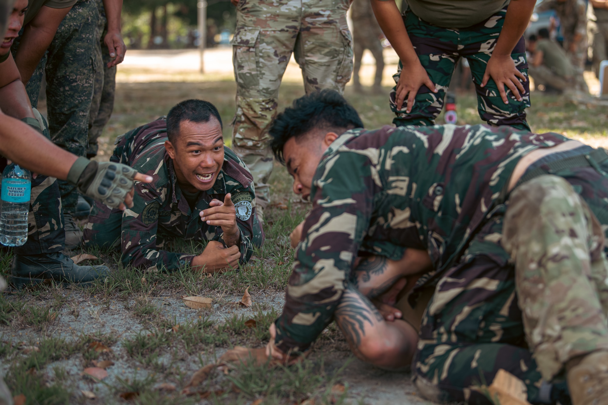 A Philippine Air Force member coaches another member while they practice combatives