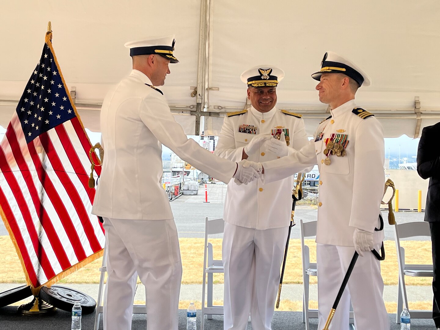 Cmdr. Adam Disque (left) shakes hands with Cmdr. Brian Tesson during the Coast Guard Cutter Active’s (WMEC 618) change of command ceremony in Port Angeles, Washington, June 28, 2023. Vice Adm. Andrew Tiongson, commander Coast Guard Pacific Area, presided over the ceremony where Disque relieved Tesson as Active’s 30th commanding officer. U.S. Coast Guard courtesy photo.
