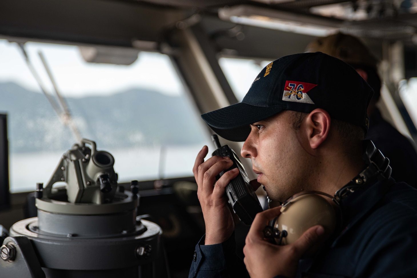 Aviation Ordnanceman 1st Class Sean Balboa, from Miami, communicates through a radio in the bridge of the U.S. Navy’s only forward-deployed aircraft carrier, USS Ronald Reagan (CVN 76), as the ship prepares to depart Da Nang, Vietnam, following a scheduled port visit, June 30, 2023. Ronald Reagan, the flagship of Carrier Strike Group 5, provides a combat-ready force that protects and defends the United States, and supports alliances, partnerships and collective maritime interests in the Indo-Pacific region.