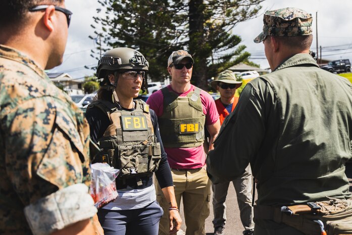 Agents with the Federal Bureau of Investigation speak with U.S. Marine Corps explosive ordnance disposal technicians with Headquarters Battalion, Marine Corps Base Hawaii before entering a simulated crime scene during Exercise Lethal Breeze 2023, Camp H. M. Smith, MCBH, June 28, 2023. The exercise was conducted in partnership with state and federal law enforcement and local first responders, with the purpose of enhancing cohesion, response proficiency, and safety measures throughout the installation. (U.S. Marine Corps photo by Cpl. Brandon Aultman)