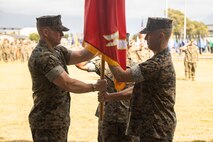 U.S. Marine Corps Lt. Col. Harry P. Consaul, left, incoming commanding officer of Headquarters Battalion, Marine Corps Base Hawaii, receives the battalion colors from Lt. Col. Stephen M. McNeil, outgoing commanding officer of Headquarters Battalion, MCBH, during a change of command ceremony at MCBH, June 23, 2023. McNeil relinquished command to Consaul. (U.S. Marine Corps photo by Sgt. Julian Elliott-Drouin)