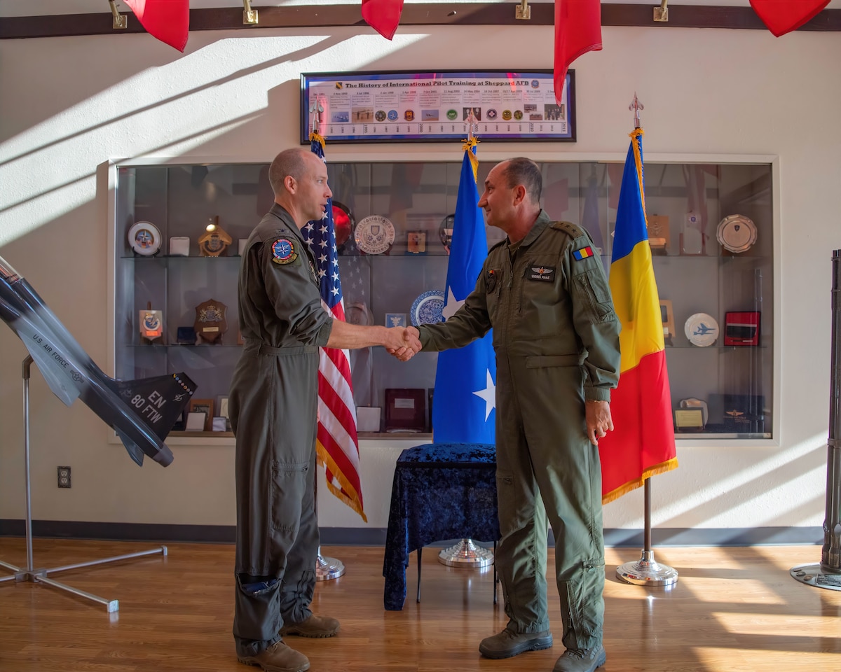 Col. Scott Gunn (left), Vice Commander of the 80th Flying Training Wing and Euro-NATO Joint Jet Pilot Training (ENJJPT), exchanges challenge coins with Chief of the Romanian Air Staff Lt. Gen. Viorel Pană (right) at Sheppard Air Force Base, Texas, June 29, 2023. Romania has been a member of ENJJPT since 2017 and the Romanian Air Force began training its first pilots there in May of 2019. (U.S. Air Force Photo by 1st Lt. Daniel Lindstrom)