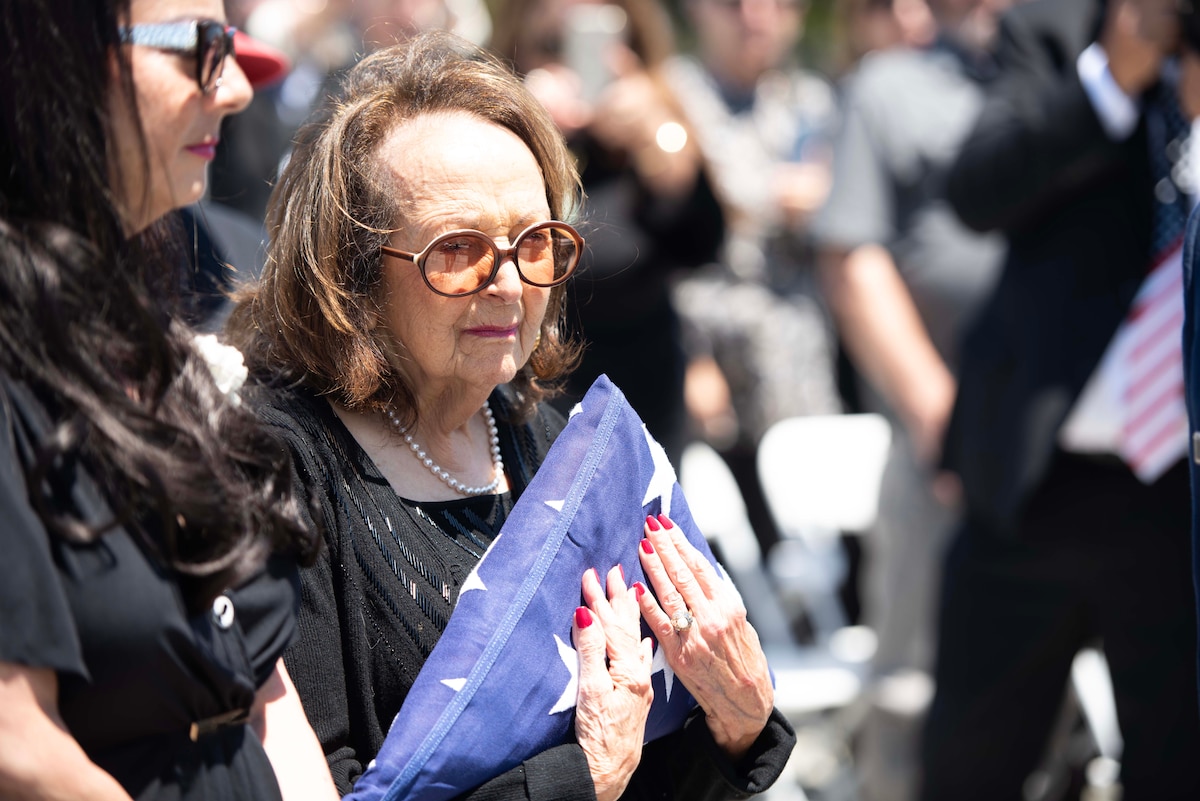 Joyce De Soto, right, holds her presented flag during the funeral honoring her husband, U.S. Air Force Col. Ernest L. De Soto at Golden Gate National Cemetery, San Bruno, California, June 30, 2023. De Soto was accounted for by the Defense POW/MIA Accounting Agency on March 23, 2023, and returned to his family for burial with full military honors. (U.S. Air Force photo by Senior Airman Alexander Merchak)