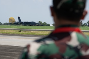A member of the Tentara Nasional Indonesia Angkatan Udara, or Indonesian Air Force, watches as a U.S. Air Force B-52H Stratofortress assigned to the 23rd Bomb Squadron at Minot Air Force Base, North Dakota, taxis upon landing at the Kualanamu International Airport in Medan, Indonesia, June 19, 2023. Two B-52s arrived in Indonesia to participate in bilateral training exercises, marking the first time U.S. Air Force B-52s had landed on Indonesian soil. (U.S. Air Force photo by Tech. Sgt. Zade Vadnais)