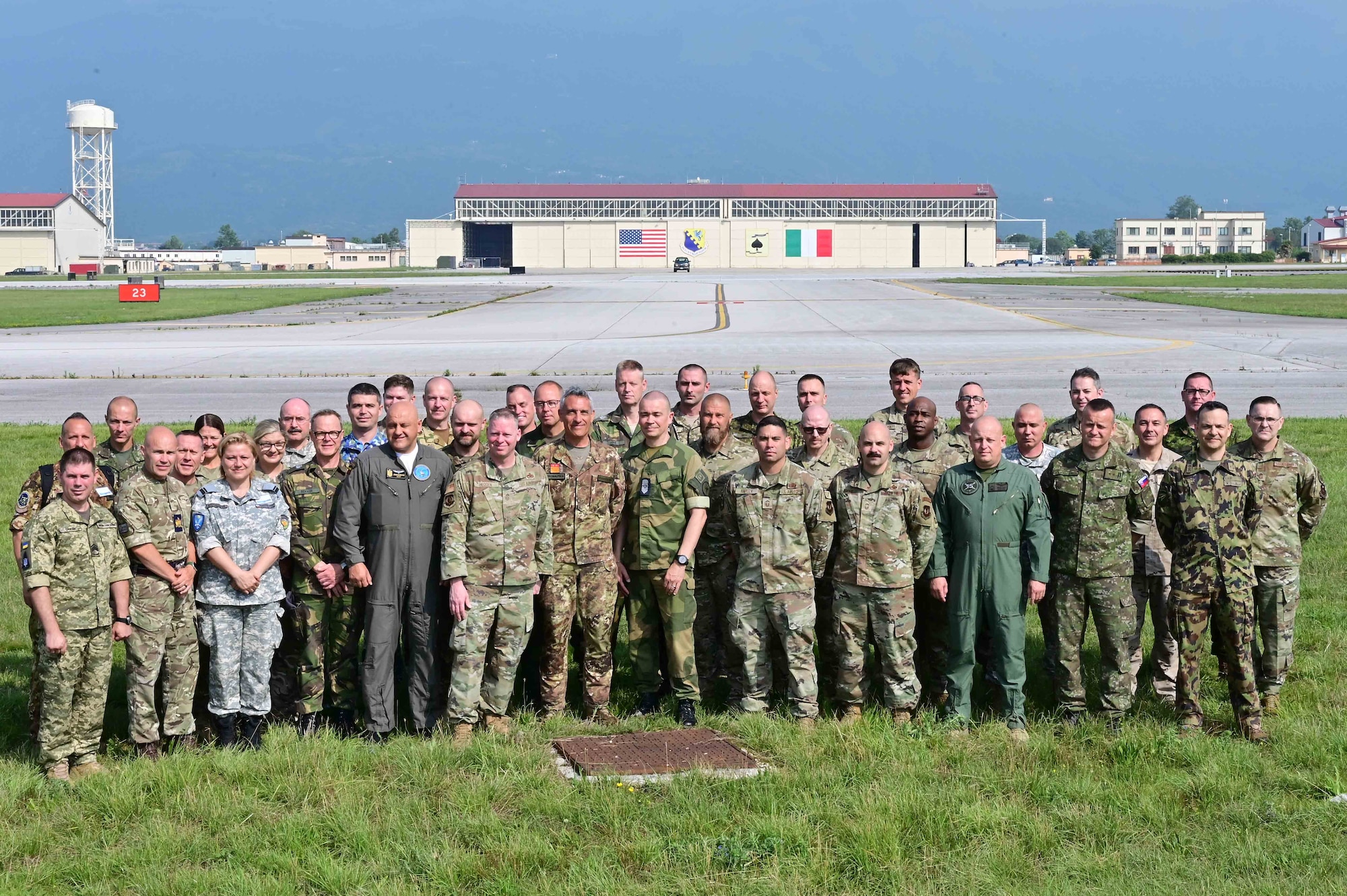 A group of chiefs pose for a photo in front of a hangar
