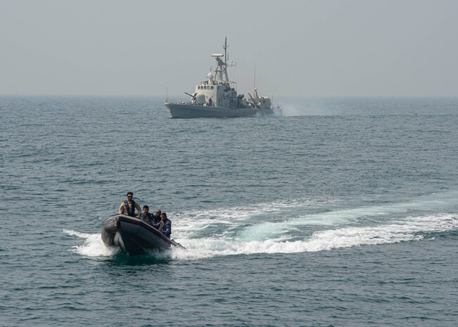 230226-N-NH267-1046 ARABIAN GULF (Feb. 26, 2023) Members of Bahrain’s armed forces ride a small boat from RBNS Ahmad Al Fateh (P20) to guided-missile destroyer USS Paul Hamilton (DDG 60) in the Arabian Gulf, Feb. 26, 2023. Paul Hamilton is deployed to the U.S. 5th Fleet area of operations to help ensure maritime security and stability in the Middle East region.
