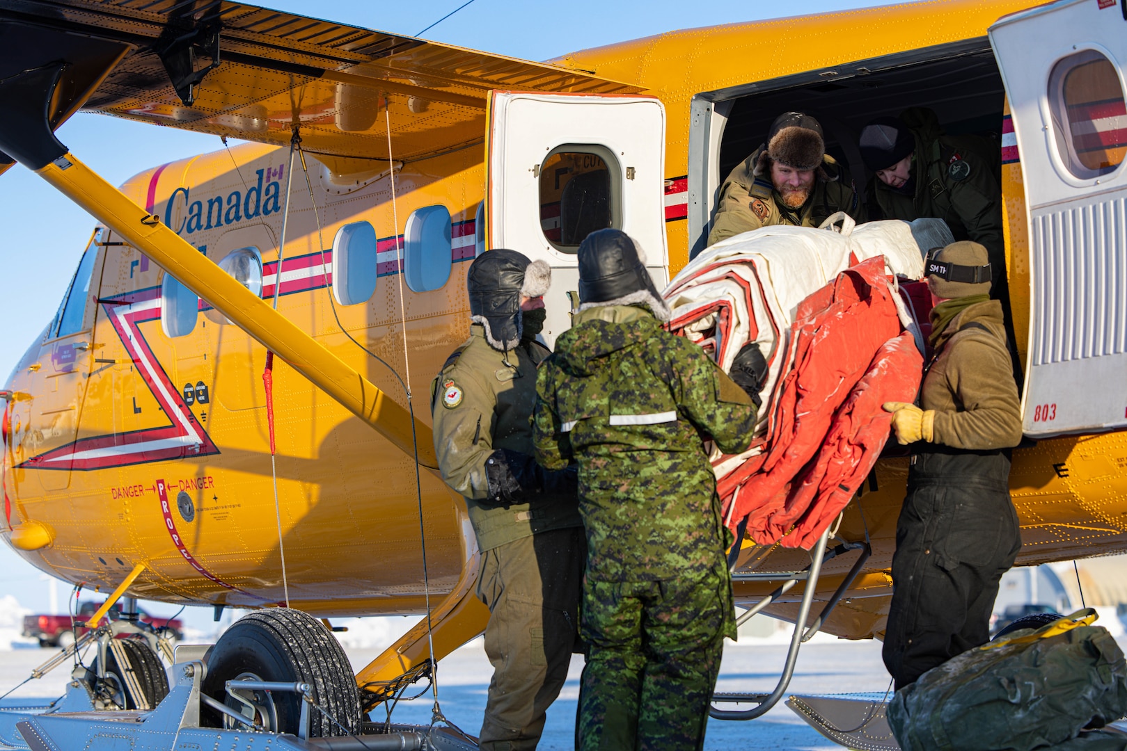 Airmen from the 109th Airlift Wing’s Polar Camp Skiway Team and members from the 440 Transport Squadron, Royal Canadian Armed Forces, load equipment and fuel into a Twin Otter aircraft at Resolute Bay, Nunavut, Canada, Feb. 27, 2023, to prepare for Exercise Guerrier Nordique. The Vermont National Guard is also participating in the exercise.