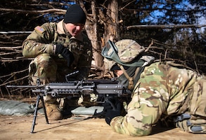 (From left to right) U.S. Army Sgt. Miguel L. Sheets, an infantryman assigned to Alpha Company, 1st Battalion, 16th Infantry Regiment, 1st Armored Brigade Combat Team, 1st Infantry Division, instructs Spc. Jason L. Willett-Brown, a culinary specialist assigned to Fox Company, 1st Battalion, 5th Field Artillery Regiment, 1ABCT, 1st Inf. Div., on the M249 Squad Automatic Weapon at Fort Riley, Kansas, Feb 26, 2023.  Willett-Brown is training to earn the Expert Soldier Badge as a part of the Big Red One 'E3B' event.  (U.S. Army photo by Pfc. Dawson Smith)