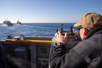 Cmdr. Joshua Tiley finds the bearing of USNS Arctic (T-AOE 8) from aboard USS Nitze (DDG 94).