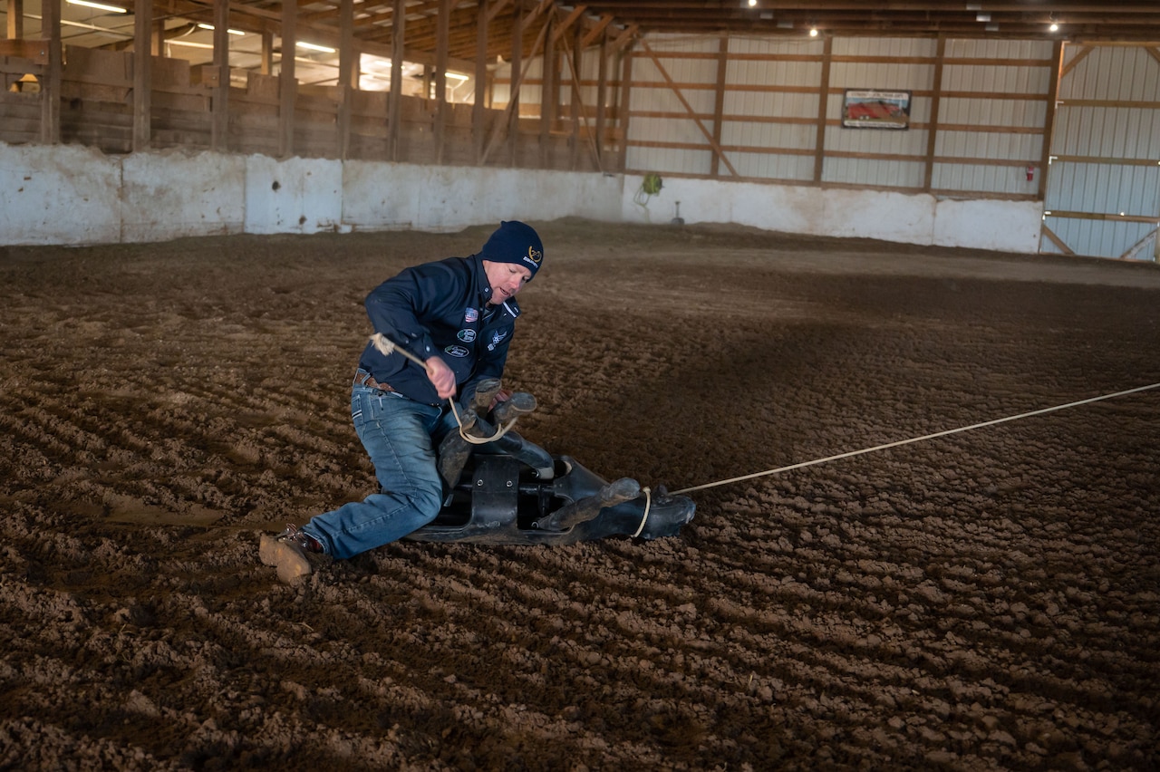 A man is shown practicing a tie down roping.