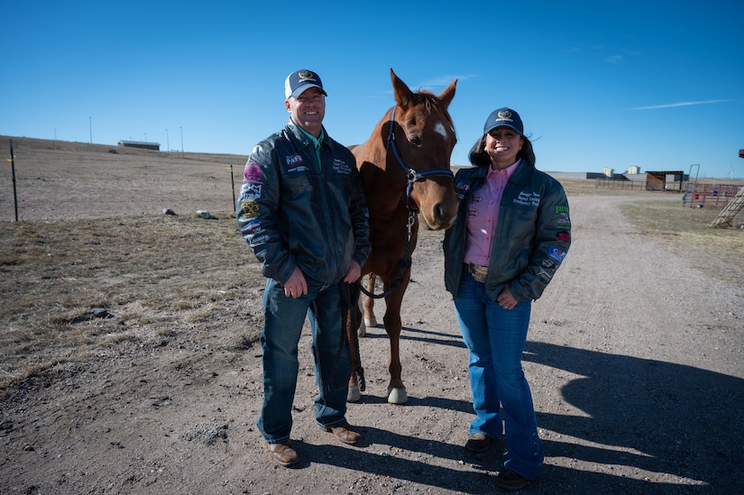 Two people stand with a horse.