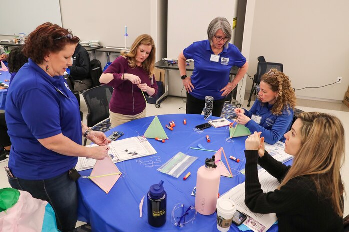 The Department of Defense 2022-2023 Albert Einstein Distinguished Educator Fellow  Dr. Nicole Yemothy (left) and 2022-2023 Albert Einstein Distinguished Educator Fellow for the National Science Foundation, working in the National Science Board Office, Vida Treviño (center), explain how to build a kite STEM kit to local area teachers Tonya Smith (left center), Piccowaxen Middle School; Maria Kayes (right center), Piccowaxen Middle School; and Britney Plunkett (right), Dr. James Craik Elementary School. Naval Surface Warfare Center Indian Head Division, supported by the Energetics Technology Center, Inc., partnered with the United States Naval Academy to conduct a “Train the Trainer” class for teachers in the Charles County, Maryland area. (U.S. Navy photo by Matthew Poynor)