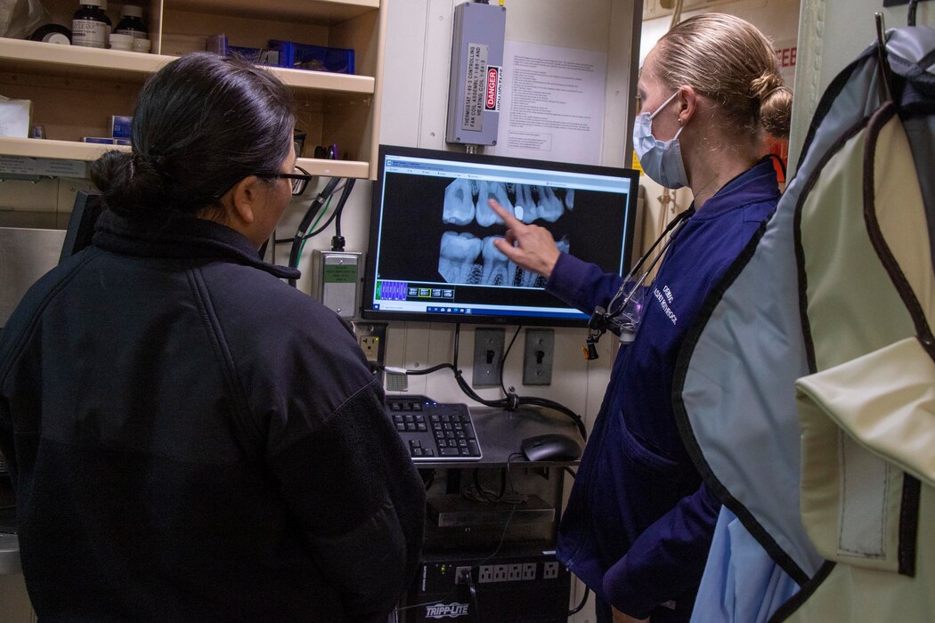 230227-N-HX806-2035 SINGAPORE (Feb. 27, 2023) – Lt. Ashly Rothrock, right, talks to Lt. Cmdr. Isabel Bray about dental x-ray scans aboard amphibious transport dock USS Anchorage (LPD 23), Feb. 27, 2023. Navy dentists provide direct dental support to Sailors and Marines and deploy in support of combat operations, disaster relief, and humanitarian missions. The Makin Island Amphibious Ready Group, comprised of amphibious assault ship USS Makin Island (LHD 8) and amphibious transport docks USS Anchorage (LPD 23) and USS John P. Murtha (LPD 26), is operating in the U.S. 7th Fleet area of operations with the embarked 13th Marine Expeditionary Unit to enhance interoperability with Allies and partners and serves as a ready-response force to defend peace and maintain stability in the Indo-Pacific region. (U.S. Navy photo by Mass Communication Specialist 1st Class Tom Tonthat)