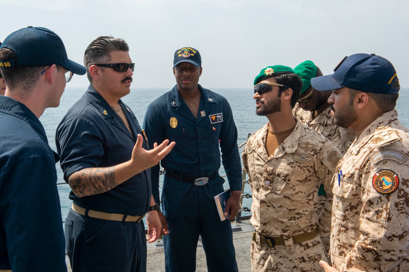 230226-N-NH267-1127 ARABIAN GULF (Feb. 26, 2023) Chief Gunner’s Mate Joseph Hourieh speaks with members of the Bahrain Defence Force aboard guided-missile destroyer USS Paul Hamilton (DDG 60) in the Arabian Gulf, Feb. 26, 2023. Paul Hamilton is deployed to the U.S. 5th Fleet area of operations to help ensure maritime security and stability in the Middle East region.